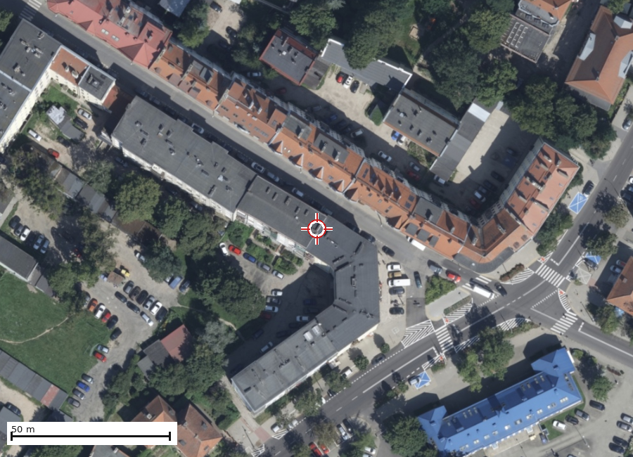 Ortofotomapa najbliższego otoczenia nieruchomości, bez warstw ewidencyjnych. Znacznik wskazuje punkt adresowy. Wycinek o szerokości 200 m.